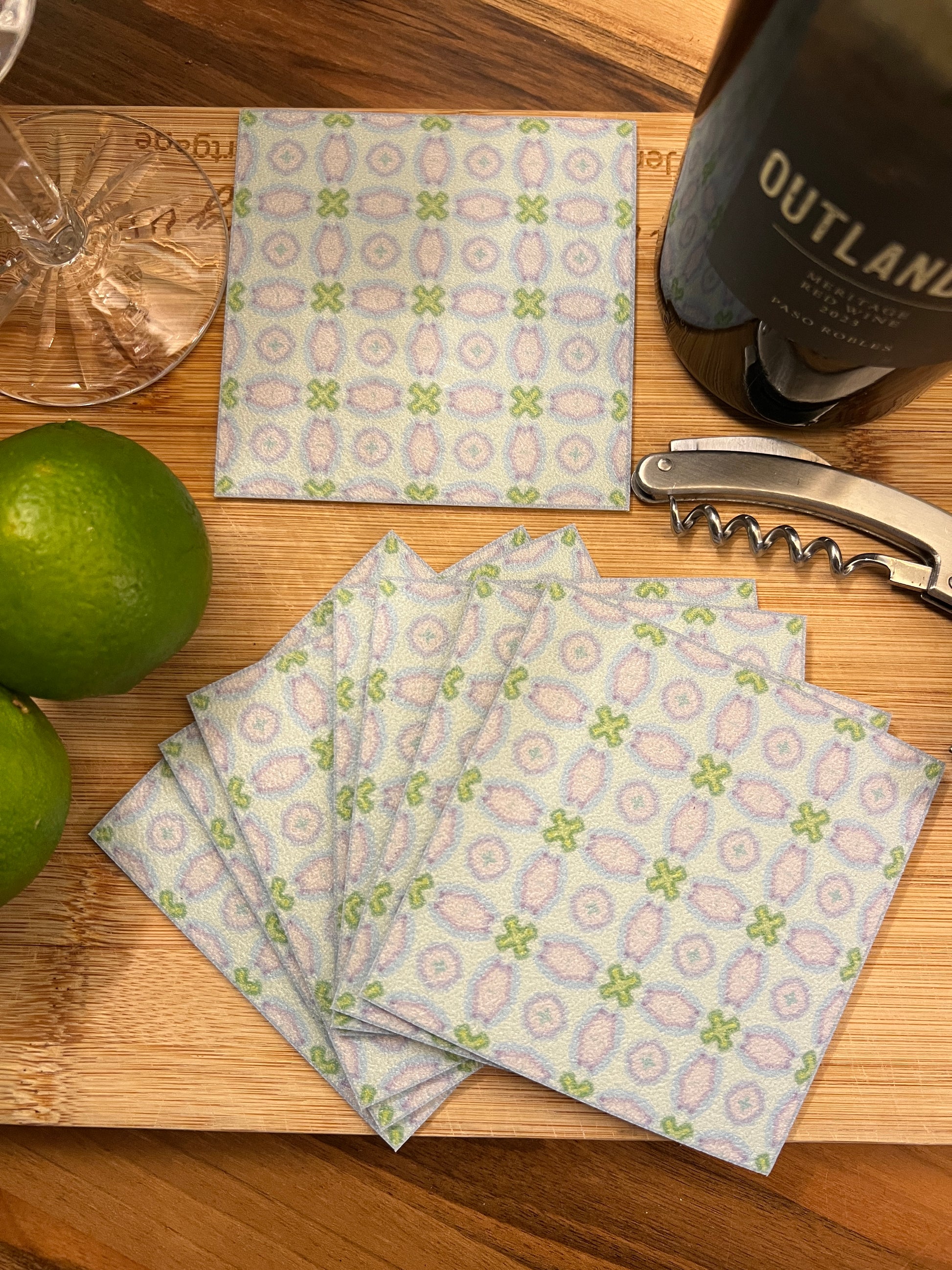 Patterned napkins on a wooden surface with a bottle and lime.
