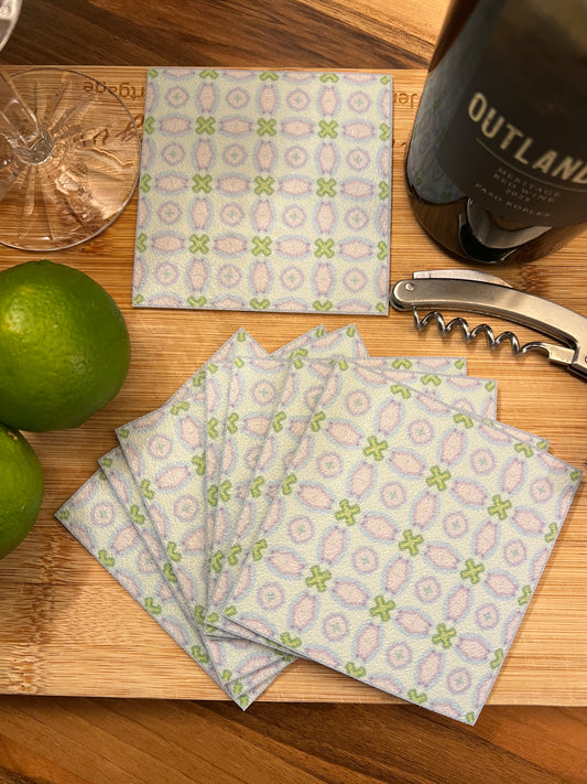 Patterned napkins on a wooden surface with a bottle and lime.