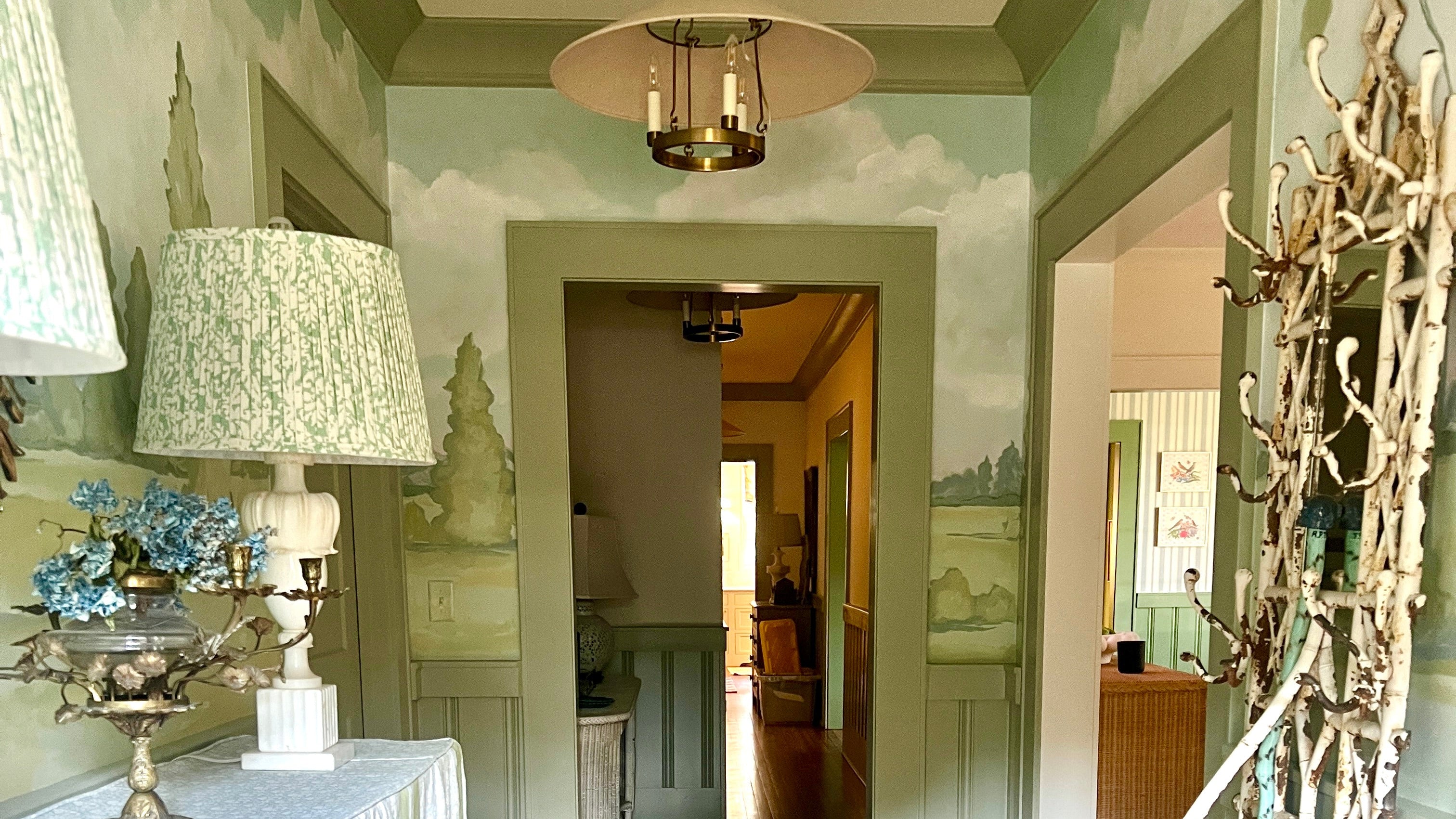 foyer hallway with hand painted decorative mural of landscape blue and green antiques cottage